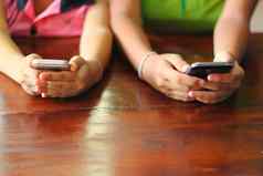 年轻的人手聪明的手机青少年分享内容社会媒体网络移动聪明的手机现代技术概念年轻的人上瘾在线手机设备