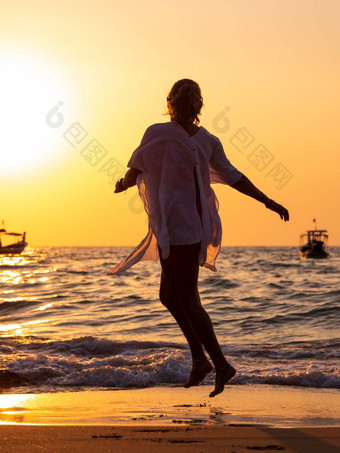 年轻的女人走海日落