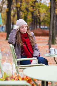 年轻的女孩户外咖啡馆秋天一天
