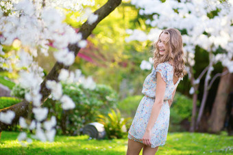 年轻的女人盛开的樱桃花园