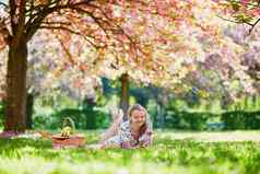 美丽的年轻的女人野餐盛开的春天公园