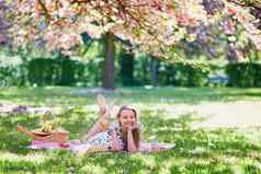 美丽的年轻的女人野餐盛开的春天公园
