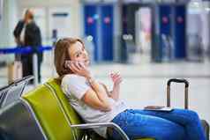 年轻的旅行者国际机场检查移动电话等待飞行