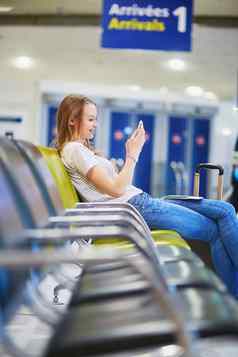 年轻的旅行者国际机场检查移动电话等待飞行