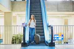 旅游女孩背包携带行李国际机场自动扶梯