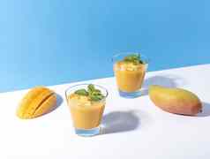 新鲜的芒果奶昔成熟的芒果片颜色背景夏天喝