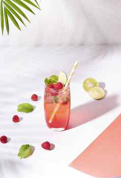冰红色的树莓穿孔鸡尾酒石灰玻璃颜色背景夏天喝