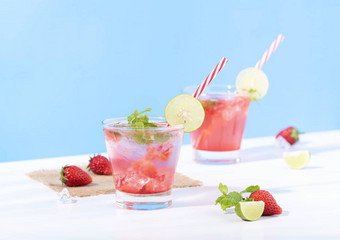 冰草莓穿孔鸡尾酒玻璃柠檬蓝色的背景夏天喝