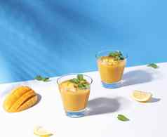 新鲜的芒果奶昔成熟的芒果片颜色背景夏天喝