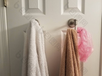 白色棕色（的）毛巾钩浴室通过粉红色的浴帽