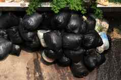 桩垃圾本黑色的前视图黑色的垃圾袋浪费塑料本袋浪费污染