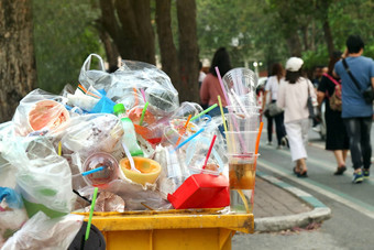 垃圾塑料浪费垃圾完整的垃圾本黄色的背景人走人行道上花园垃圾本垃圾塑料污染垃圾浪费塑料浪费