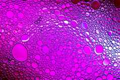 色彩斑斓的滴石油水purle彩色的圈椭圆摘要背景设计