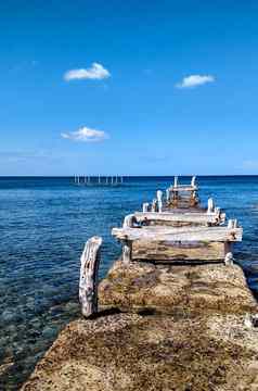 古老的废弃的码头木结构腐蚀大气事件使白色水晶清晰的蓝色的海