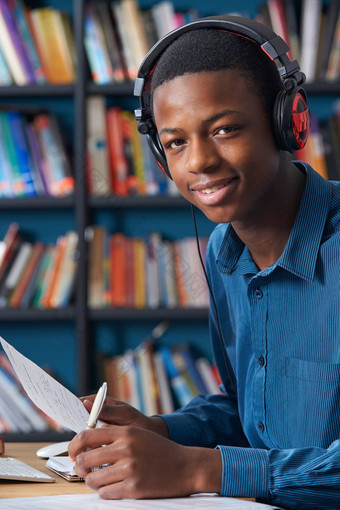 十几岁的<strong>学生穿</strong>耳机同时工作图书馆