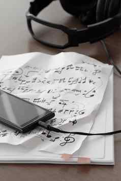 特写镜头智能手机耳机音乐的笔记纸