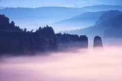 有雾的忧郁的黎明美丽的仙女谷山峰岩石修剪奶油多雾的云