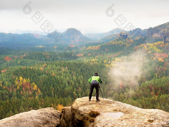 徒步旅行者相机三脚架需要图片岩石峰会摄影师边缘照片景观
