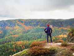 徒步旅行者运动服装站岩石看秋天的色彩斑斓的谷太阳