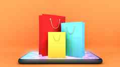 色彩鲜艳的纸购物袋移动电话橙色背景购物在线购物狂概念呈现