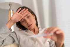 冠状病毒亚洲女人检查温度温度计电晕病毒呼吸疾病流感症状咳嗽高发热严重的情况下肺炎