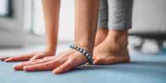 瑜伽健身工作室瑜珈老师伸展运动串联瑜伽类特写镜头手蓝色的时尚坏手镯光着脚脚首页