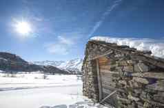 孤立的雪山小屋太阳