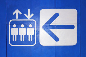 电梯图标标志白色箭头象征电梯蓝色的背景电梯象征概念警告信息标志平风格混凝土墙蓝色的