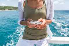 旅游智能手机移动应用程序文本短信旅行巡航船之旅女人持有电话发短信船骑旅行夏天假期