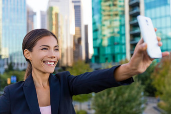 业务女人采取自拍照片聪明的电话应用程序智能手机社会媒体年轻的女商人智能手机微笑快乐温哥华加拿大在户外城市女专业