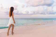 和平假期天堂女人走日落海滩柔和的颜色天空海洋宁静宁静女孩白色衣服放松奢侈品热带夏天度假