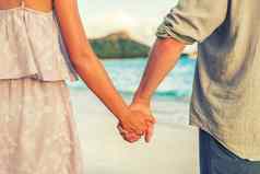 夫妇持有手放松夏威夷海滩日落年轻的人爱威基基海滩旅行火奴鲁鲁夏威夷