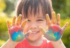 快乐的孩子女孩手画色彩斑斓的油漆