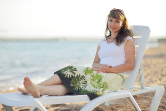 年轻的女人放松海滩码头假期旅行概念