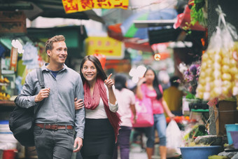 跨种族夫妇游客走购物中国人市场在香港香港中国年轻的人旅行亚洲当地的街食物亚洲女人高加索人男人。