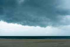 黑暗巨大的云天空黑色的狂风暴雨的云运动大雨一天海滩