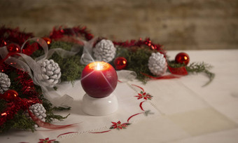 圣诞节设置红色的基斯蜡烛交叉屏幕效果前景包围松分支机构红色的装饰物红色的白色丝带白色松视锥细胞圣诞节桌布散景效果