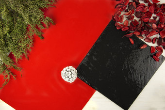 平躺几何圣诞节复制空间对角红色的条纹黑色的石灰石板松分支机构白色松锥红色的花瓣光木背景