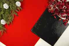 平躺几何圣诞节复制空间对角红色的条纹黑色的石灰石板松分支机构白色松视锥细胞红色的花瓣光木背景