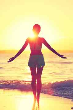 正念女人练习瑜伽太阳称呼海滩早....日出