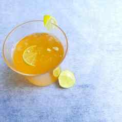 柠檬汁玻璃添加橙色糖浆冰多维数据集片柠檬内部玻璃漂亮的白色背景