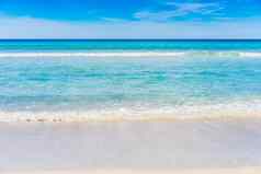 软蓝色的海洋波桑迪海滩云天空背景