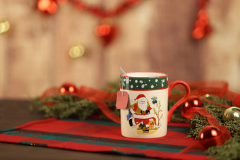 关闭圣诞节杯子挂空茶标签圣诞节表格布松分支机构红色的装饰物挂圣诞节装饰木背景散景效果