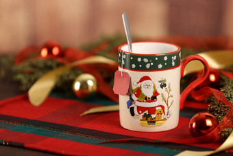 关闭圣诞节杯子挂空茶标签圣诞节表格布松分支机构红色的装饰物挂圣诞节装饰木背景散景效果