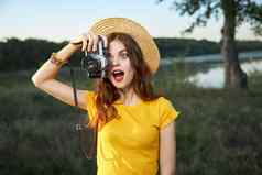 惊讶女人相机黄色的t恤他夏天自然生活方式