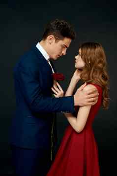 年轻的夫妇拥抱魅力红色的玫瑰的关系黑色的背景