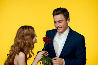 情人男人。女人红色的玫瑰手拥抱黄色的背景浪漫的关系爱家庭