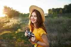 女人摄影师相机手微笑红色的嘴唇他黄色的t恤夏天自然