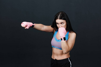 运动员女人拳击手摆姿势培训工作室黑色的背景