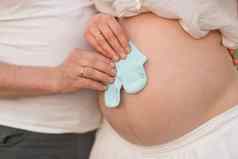 快乐时刻怀孕怀孕了女孩期待新生儿男孩夫妇买了蓝色的袜子婴儿